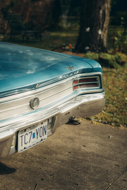 a car sitting on top of a driveway next to a tree