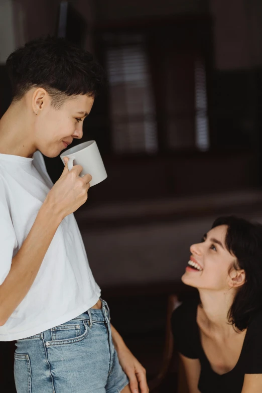 a woman in black shirt and white shirt drinking from cup