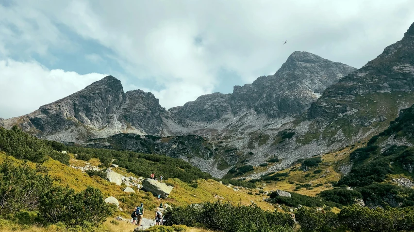 a man walking down the trail into the mountains