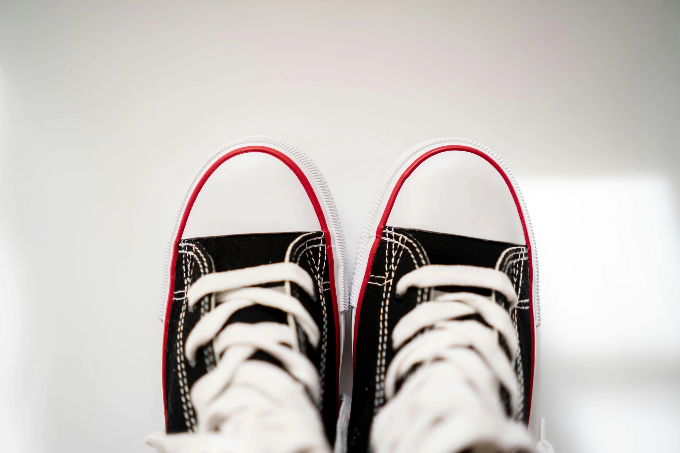 a pair of sneakers with red and black details