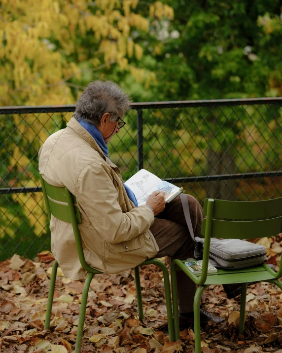 a man sitting in an empty chair reading a book