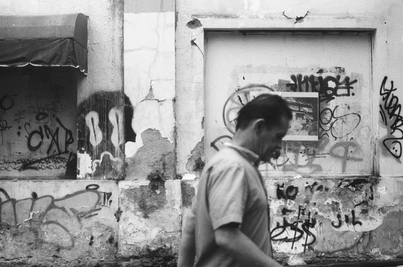 a man walks past graffiti in black and white