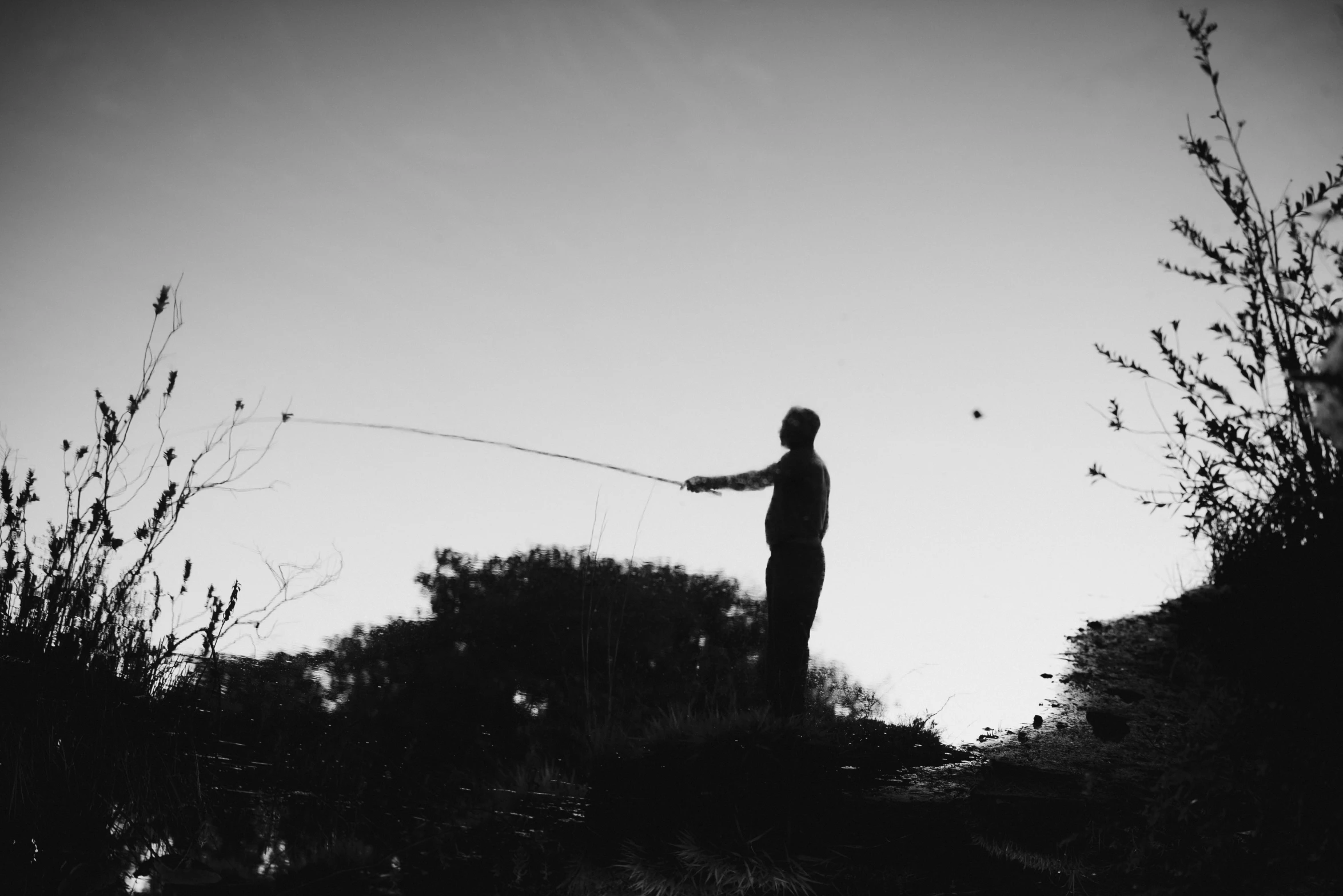 a black and white po of a person with a fish in their hand