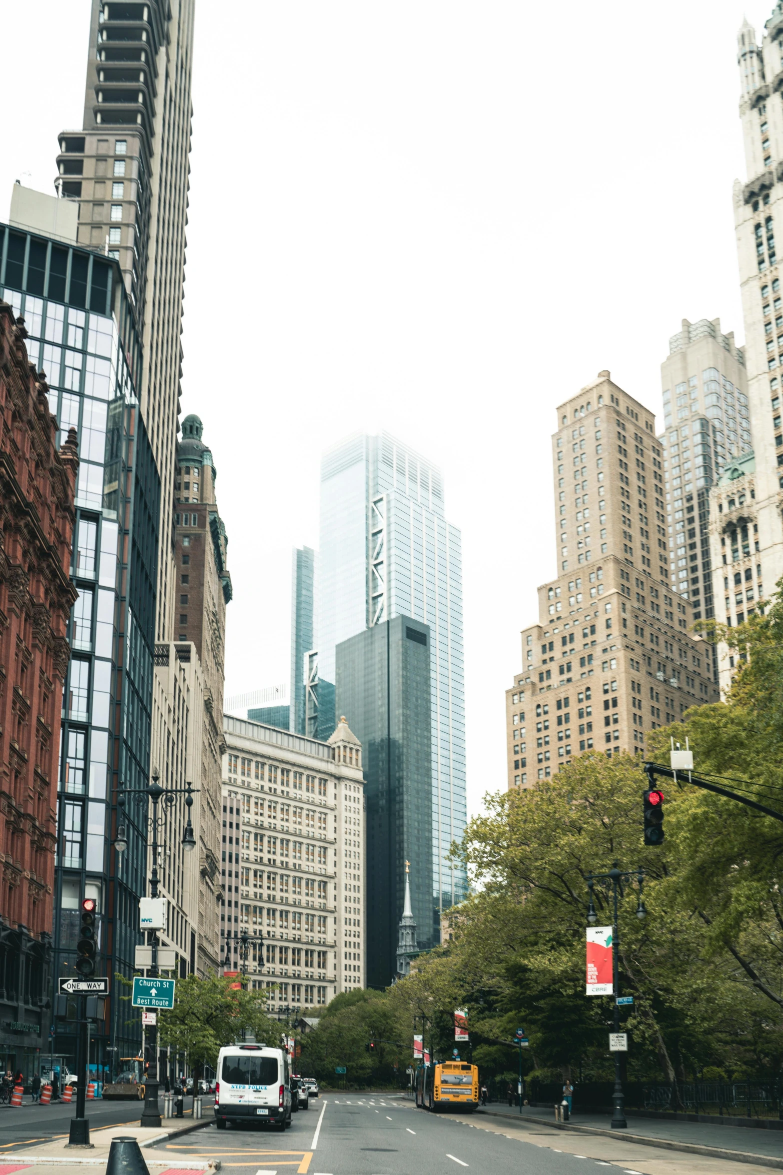 vehicles and buses on a city street with tall buildings