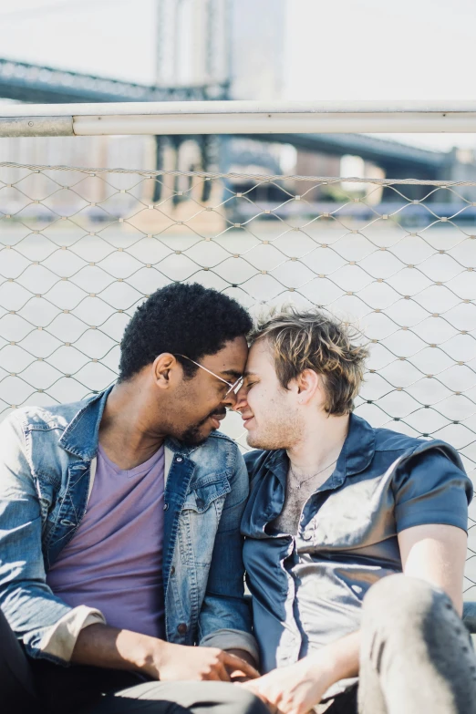 two men sit on the bench and cuddle together