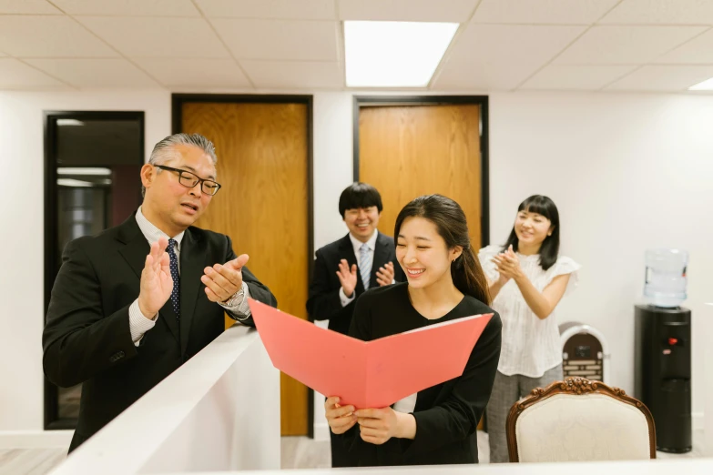 the woman is holding a folded piece of paper