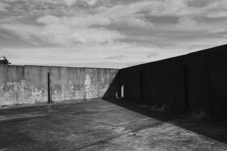 people are skateboarding near a wall on a cloudy day