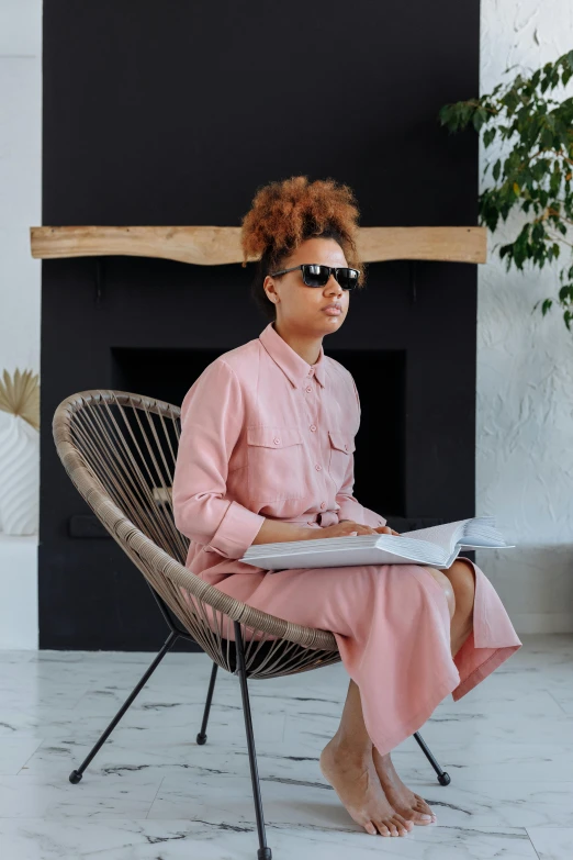 woman sitting in chair with newspaper and sunglasses