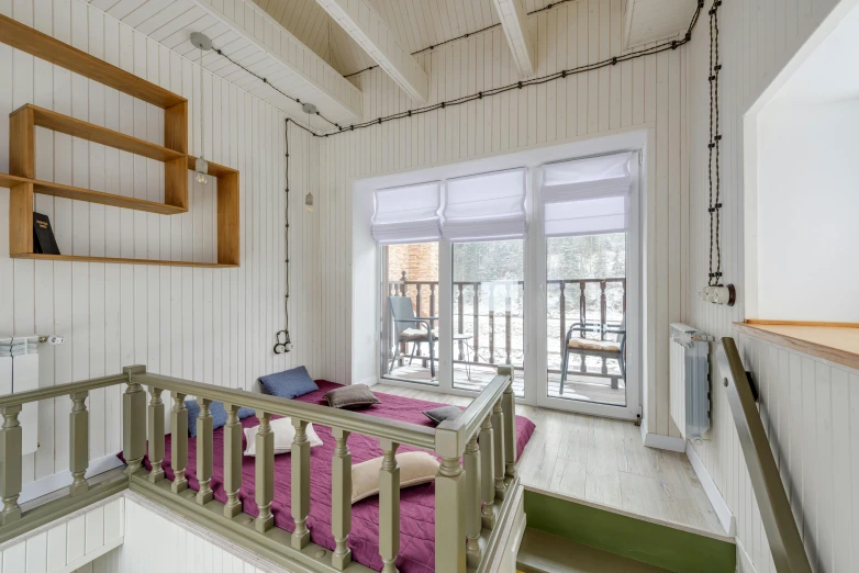 a purple bed sits in front of an open balcony door