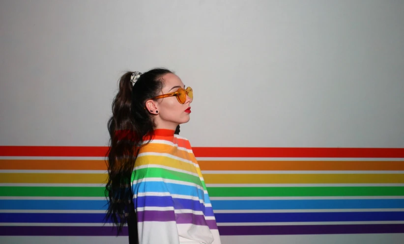 woman with pony tail and rainbow striped shirt posing