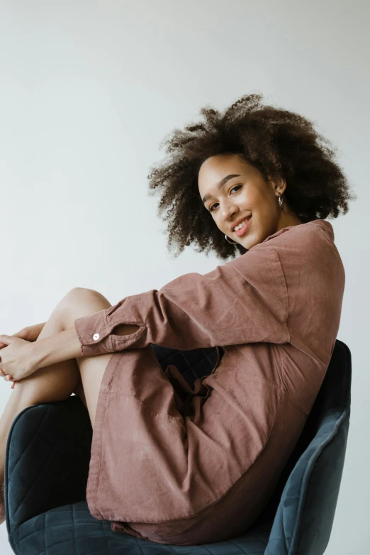 a woman with dark hair sitting in a chair