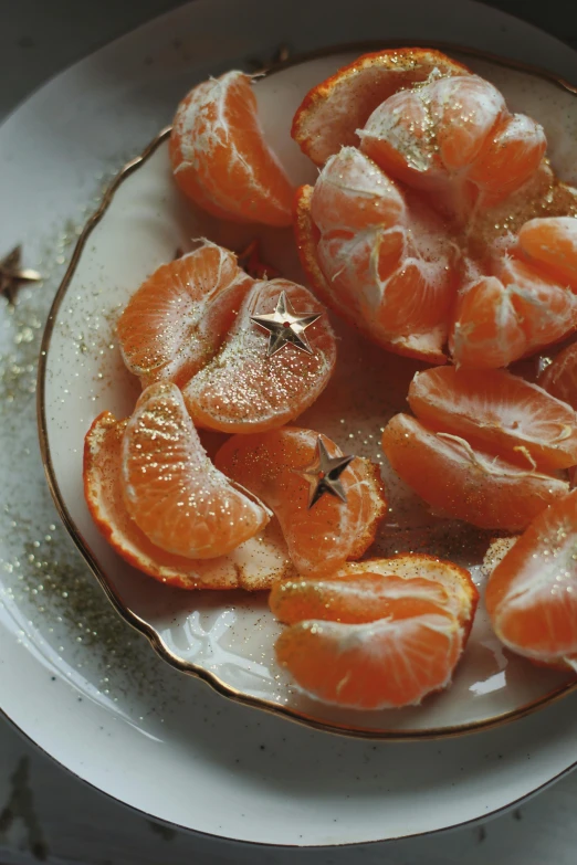 peeled oranges on a plate with stars around them