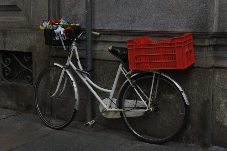 a white bicycle with a basket that has flowers in it