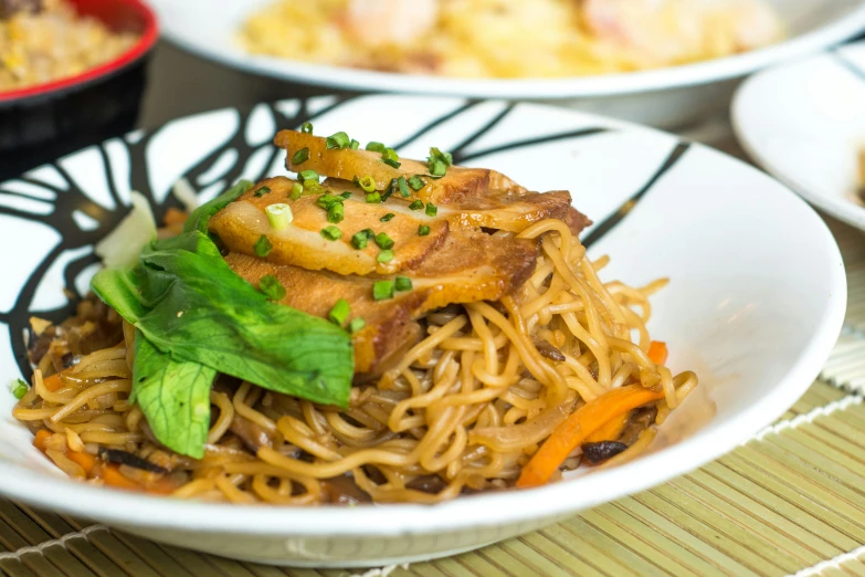 an asian dish has noodles, carrots, and other vegetables