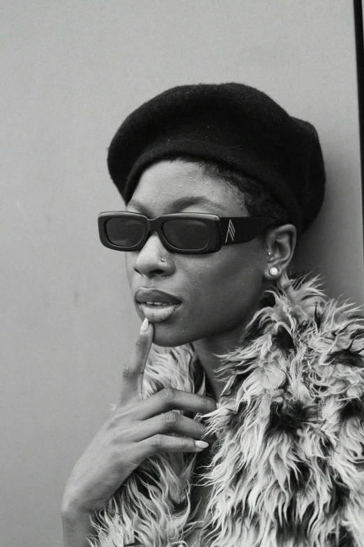 a woman with a hat, shades and a jacket