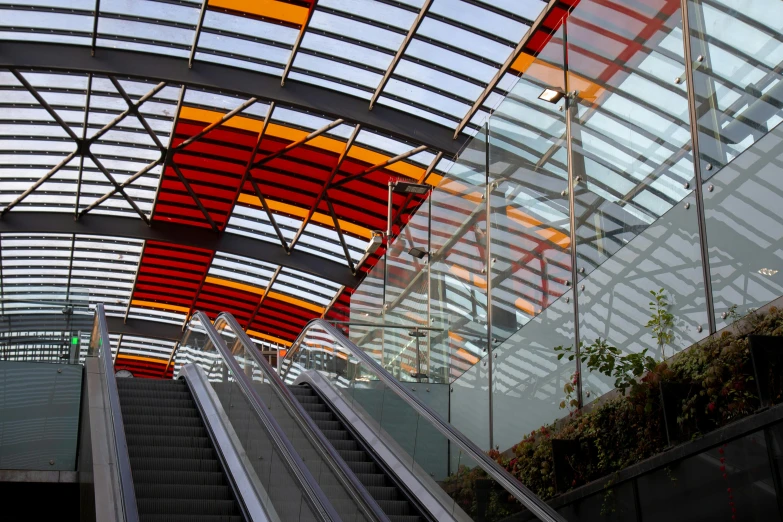 an escalator in a public building with a bright canopy over it