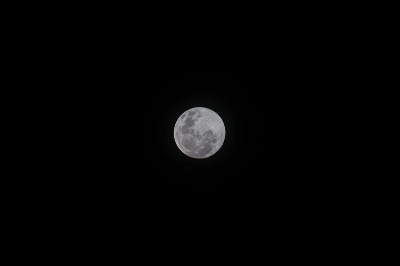 a plane flies by in the sky and a super moon is in the distance