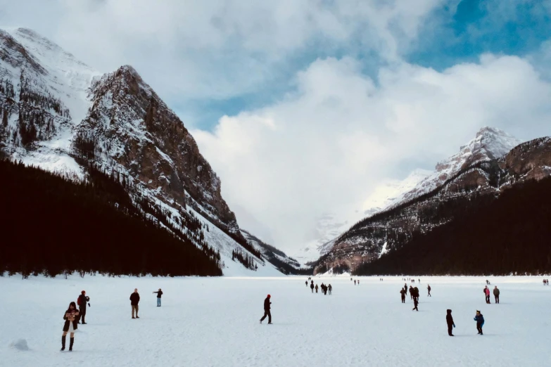 people skiing in the mountains on snow and cloudy skies