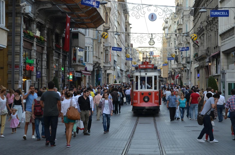 a tram car on a busy street near many people