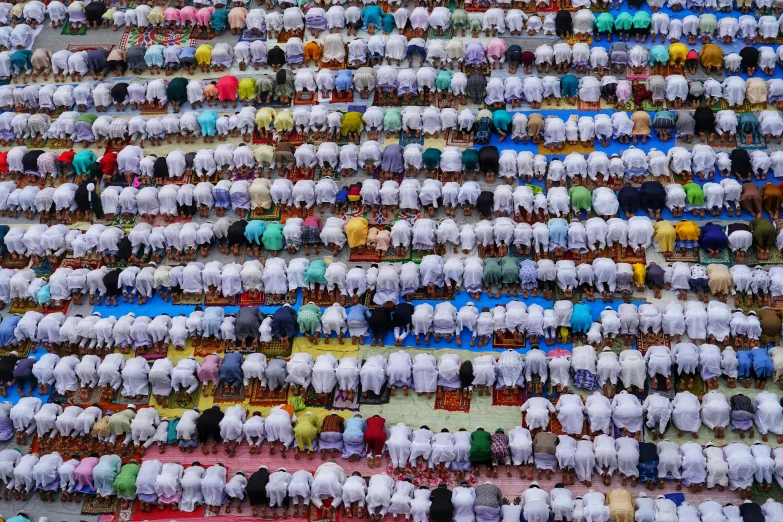 hundreds of people stand in a massive array together