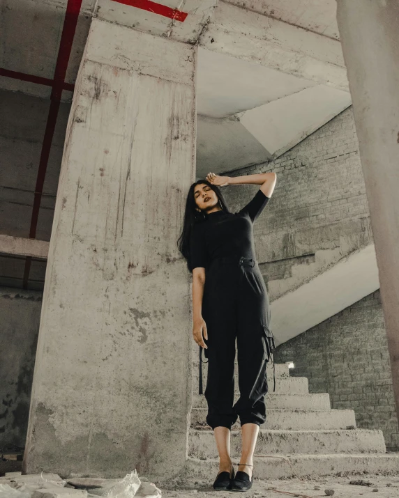 a woman posing in a room near an old structure