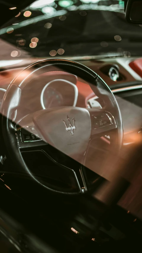 a view of the dashboard and interior of a car from behind the steering wheel