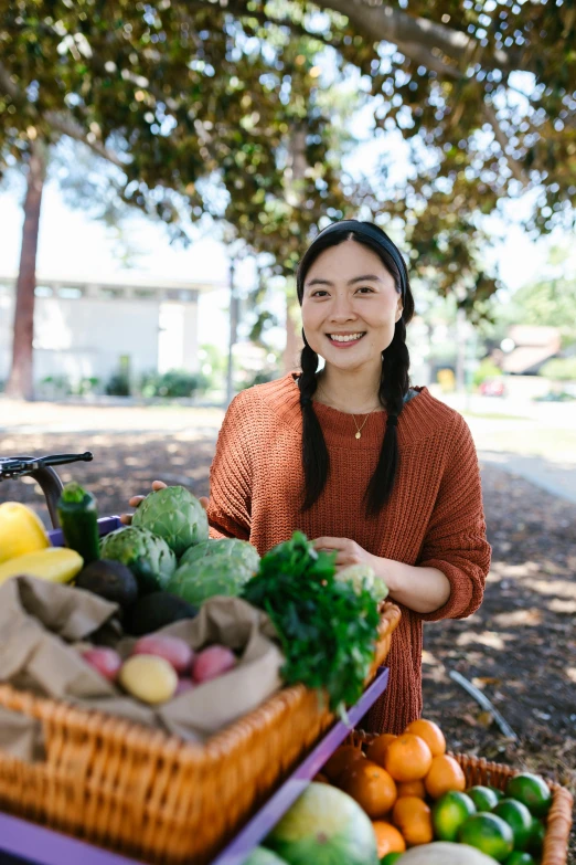 a smiling woman stands beside her harvest display