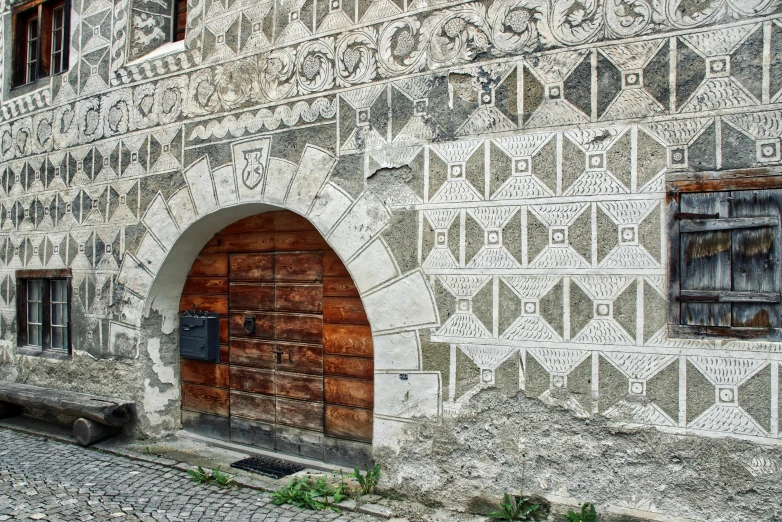 a brown door on an old building and a stone bench