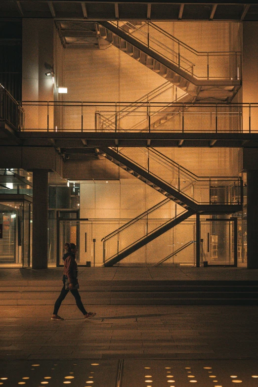 the person is walking across a large building at night