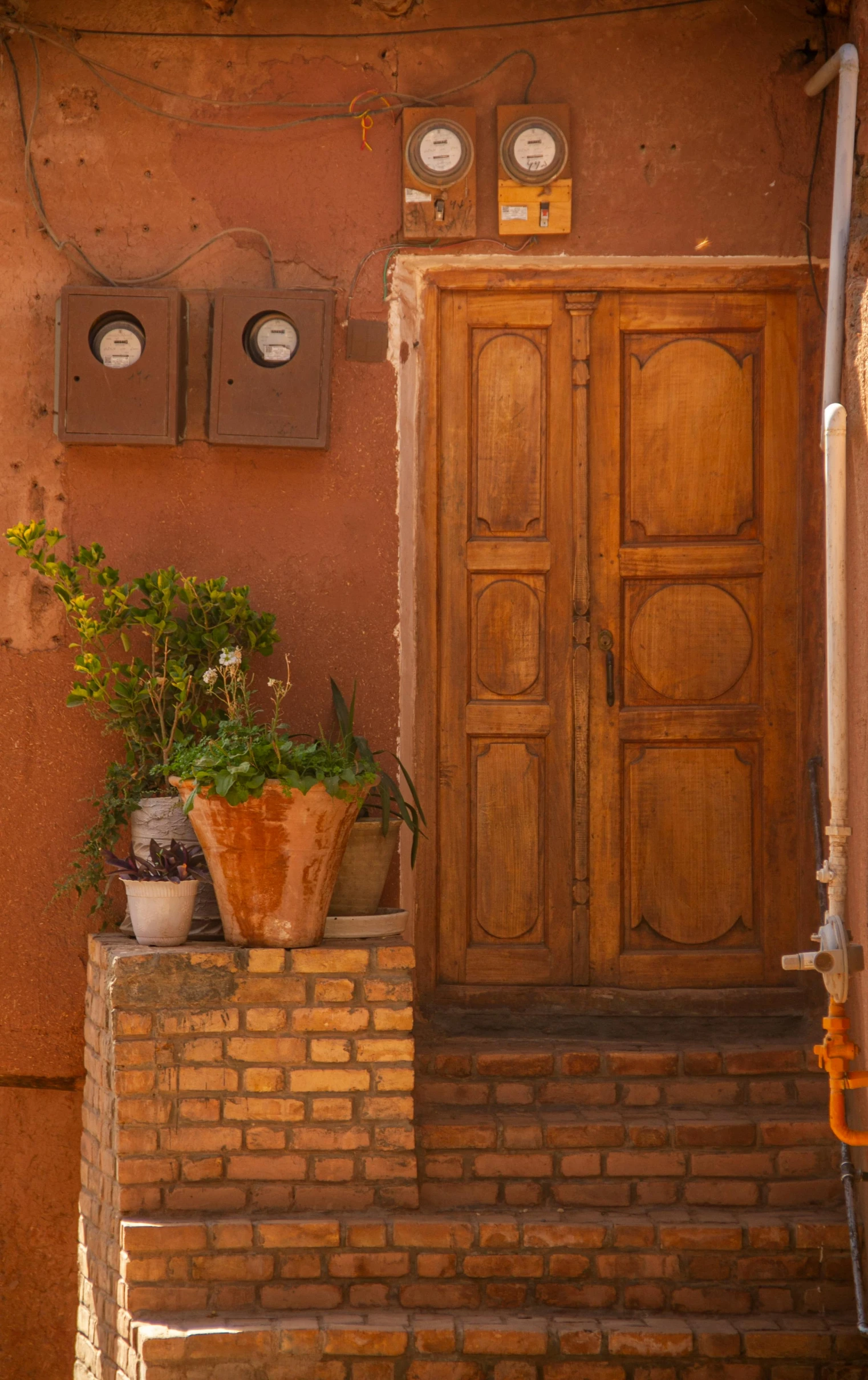 a building has a staircase that has pots and flowers in front of it