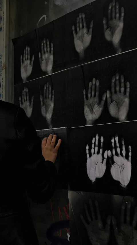 a boy holds his handprint of many different hands