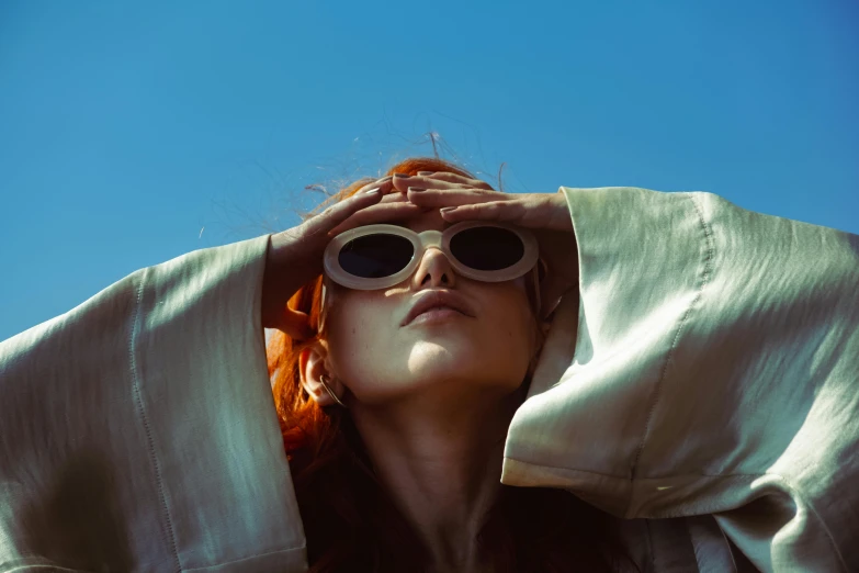 a woman wearing sunglasses covering her face