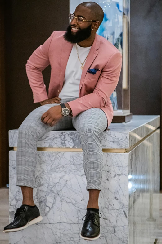 a black man with a beard is sitting on a marble statue