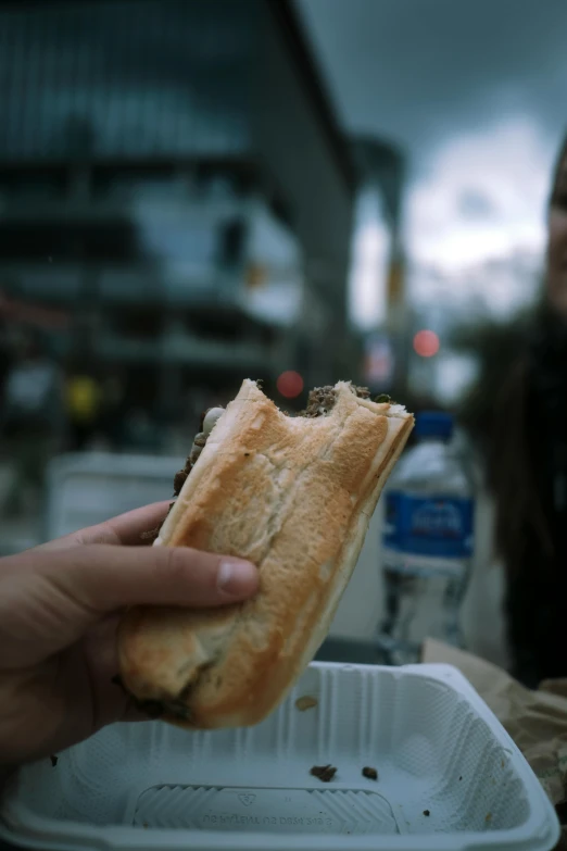 a person eating a sandwich in front of their lunch box