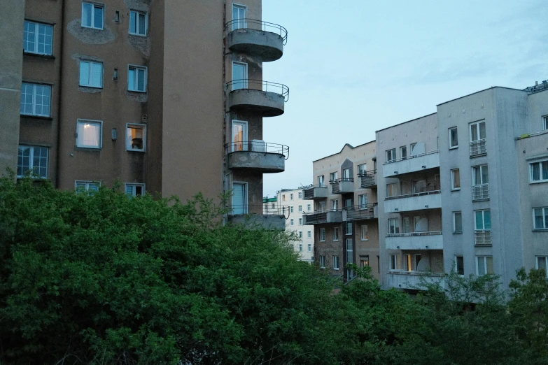 a tall building sitting next to other buildings near trees