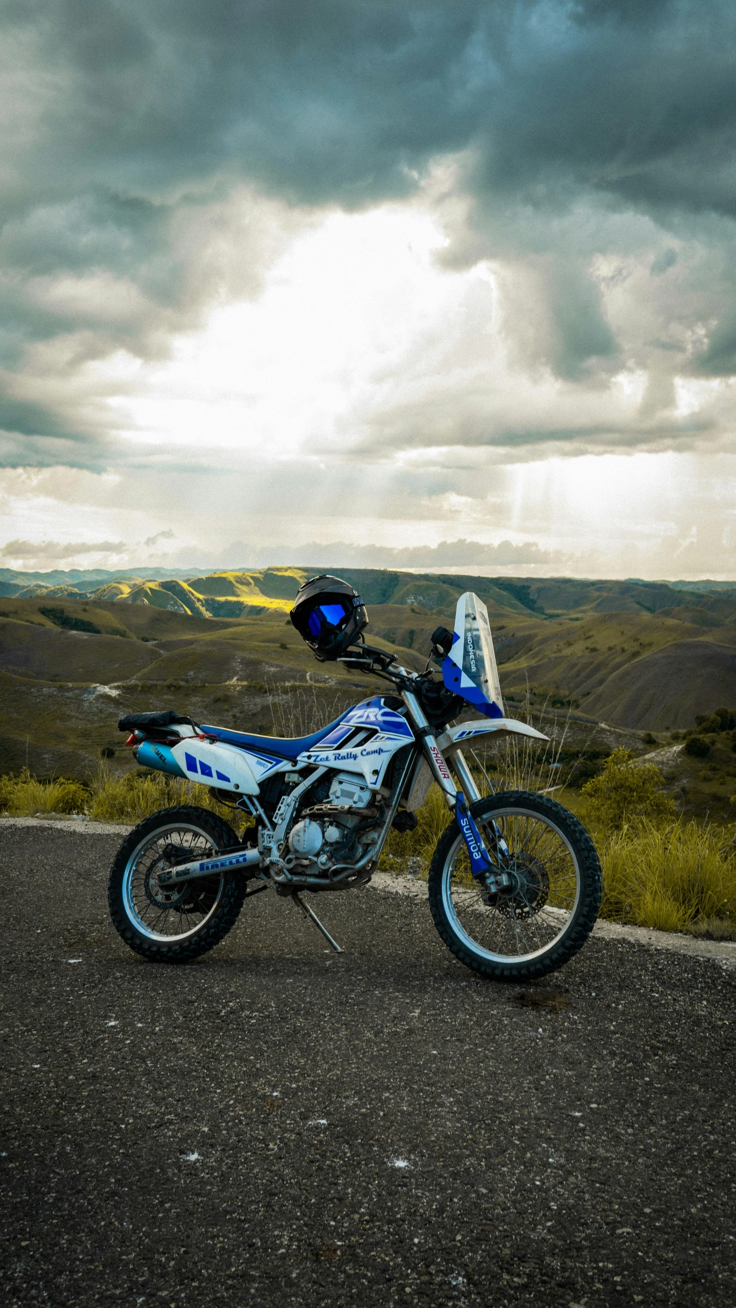 motorcycle parked on the side of the road with mountains in the background