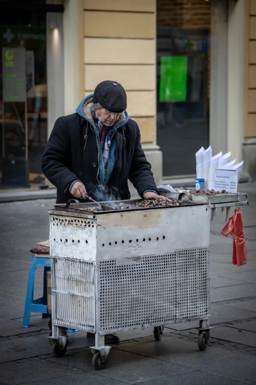 a man in the middle of street putting some food into an air cooler