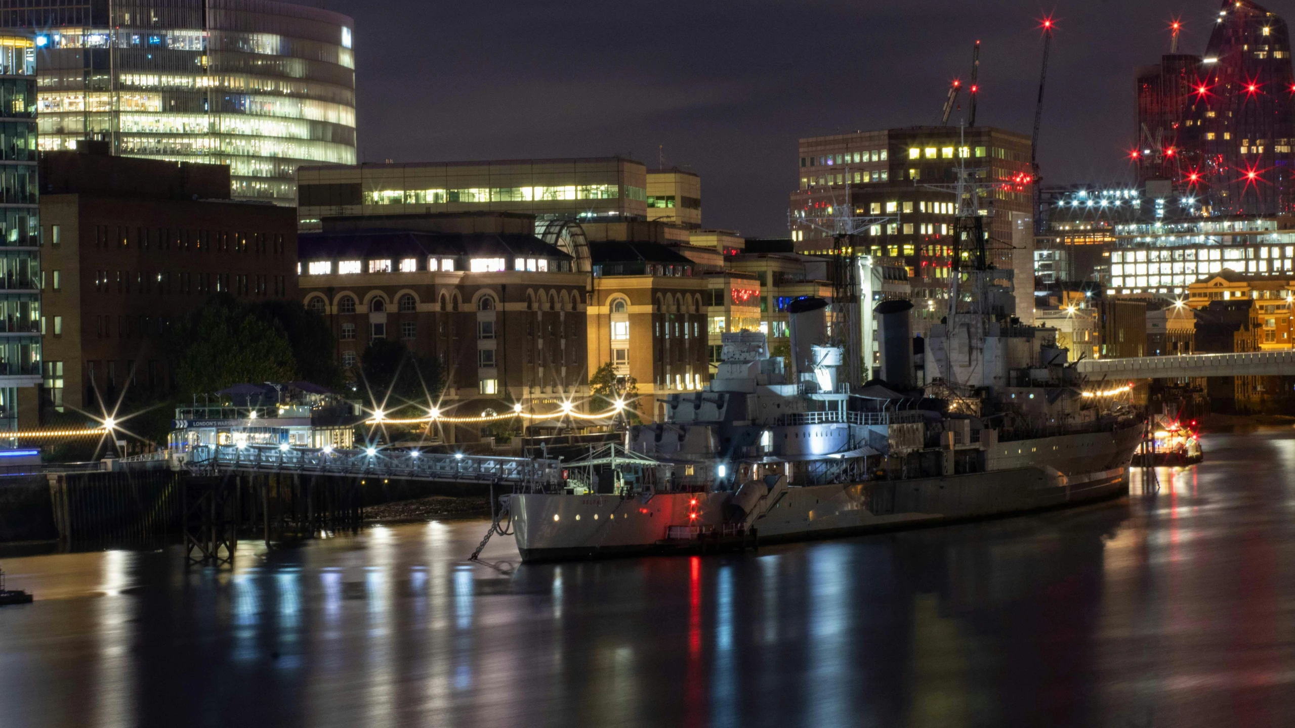 the boats are docked near the waterfront at night