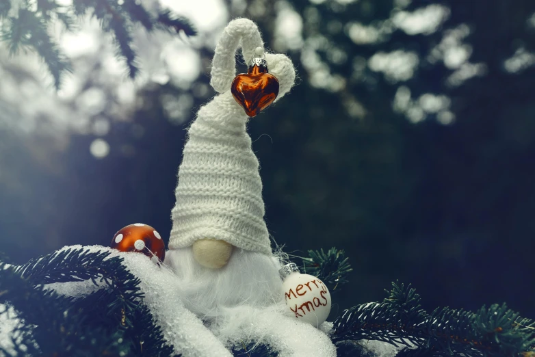 the stuffed penguin is sitting in the christmas tree