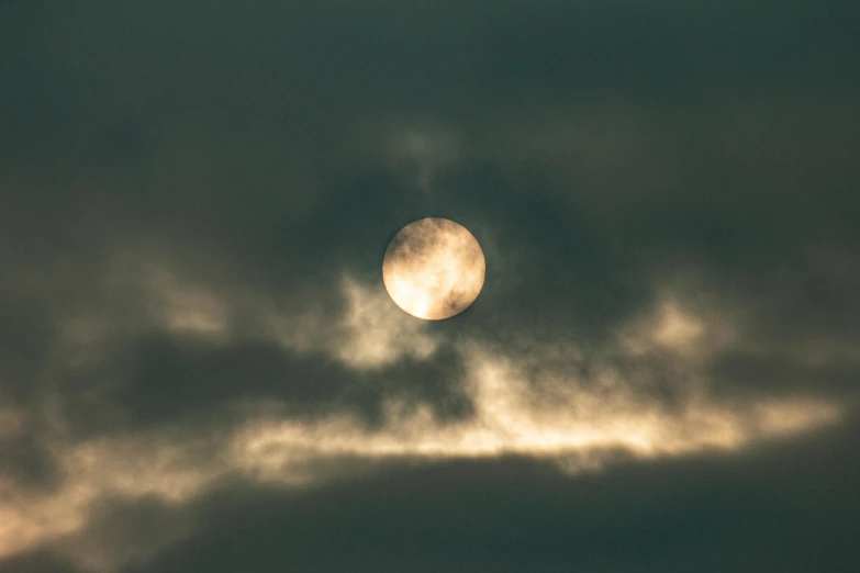 a big cloudy and very bright moon in the night sky