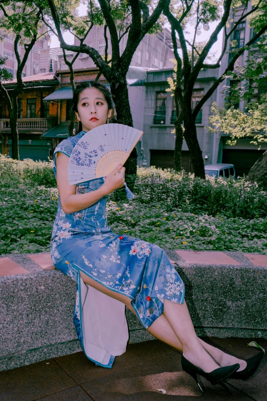 a woman sitting on a wall with a paper