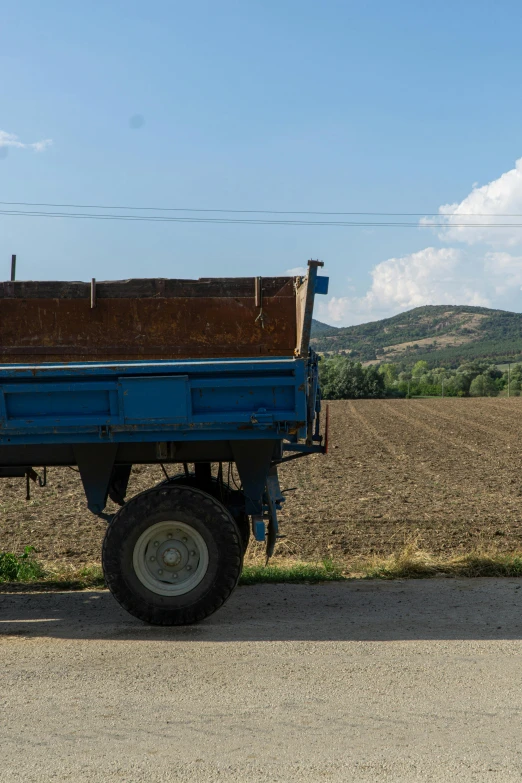 an old blue truck is standing in a field