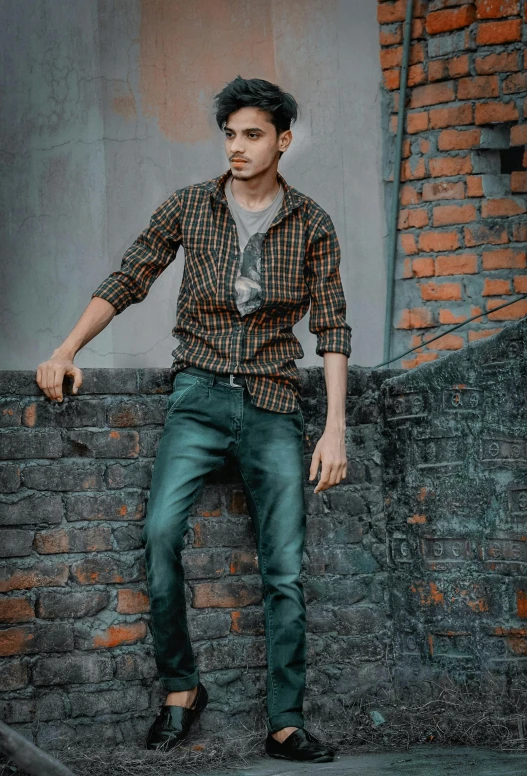 a man sitting on top of a brick wall with his hand on the handle