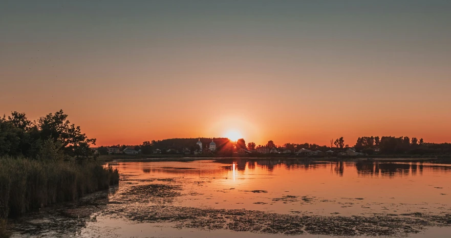 a beautiful sunrise over a lake surrounded by forest