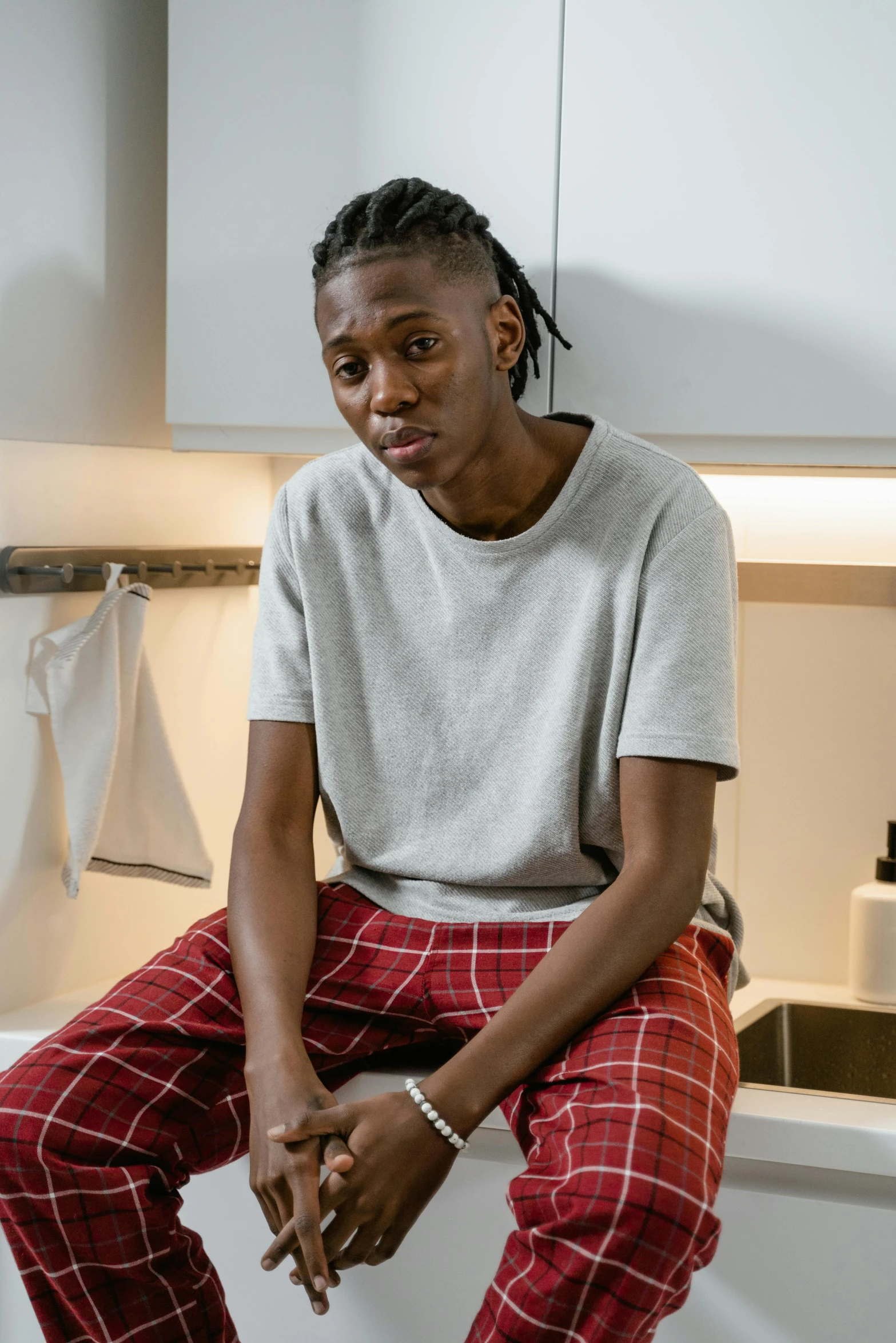 an african american man sitting on the kitchen counter