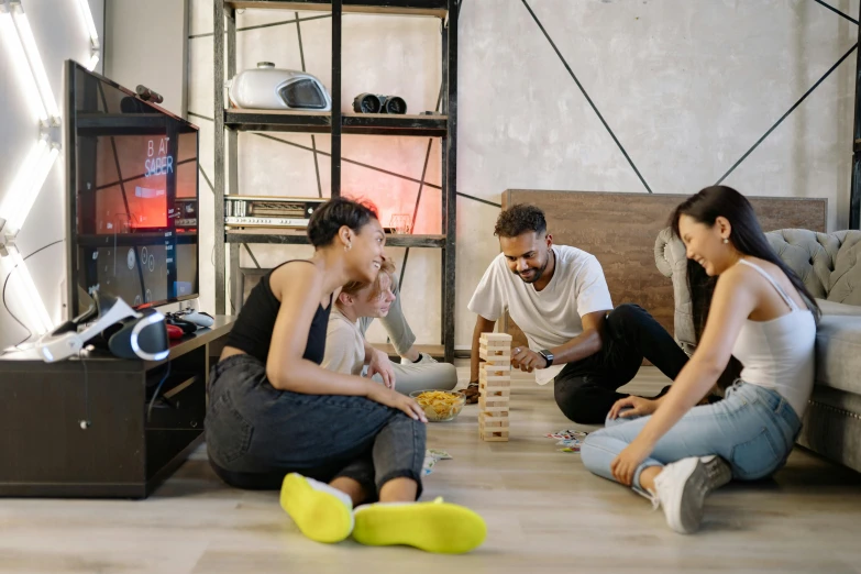 three young adults and one is playing board games