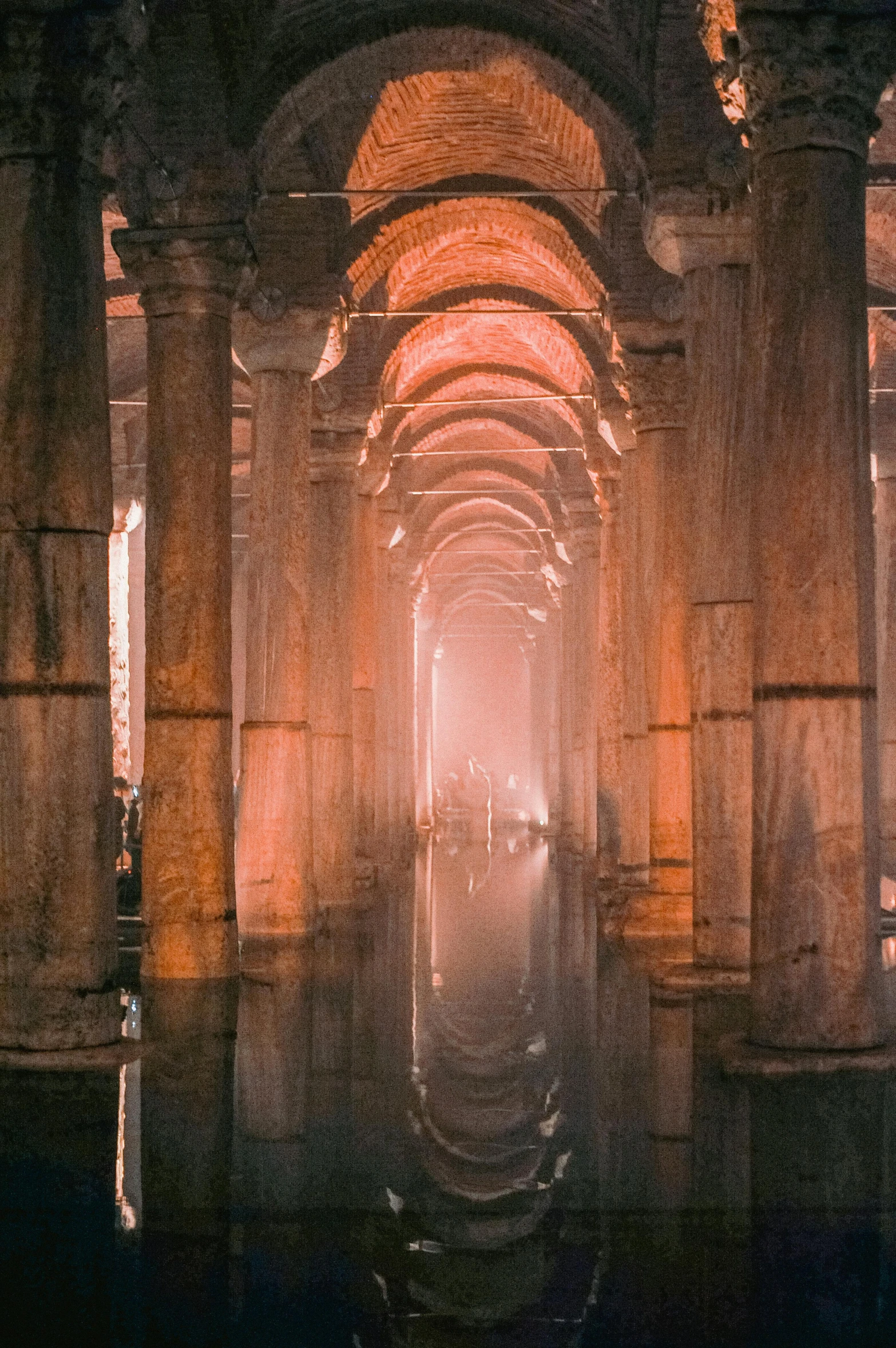 a tunnel is shown with large pillars and light from the window