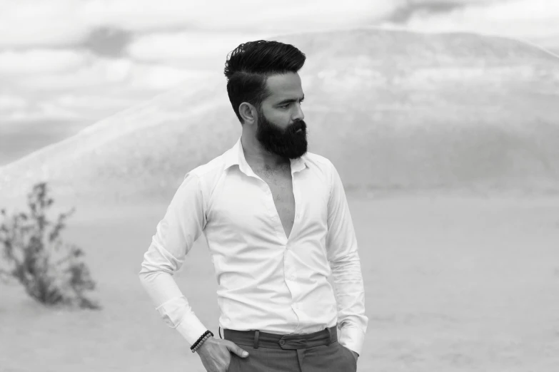 a man with a beard standing on the beach
