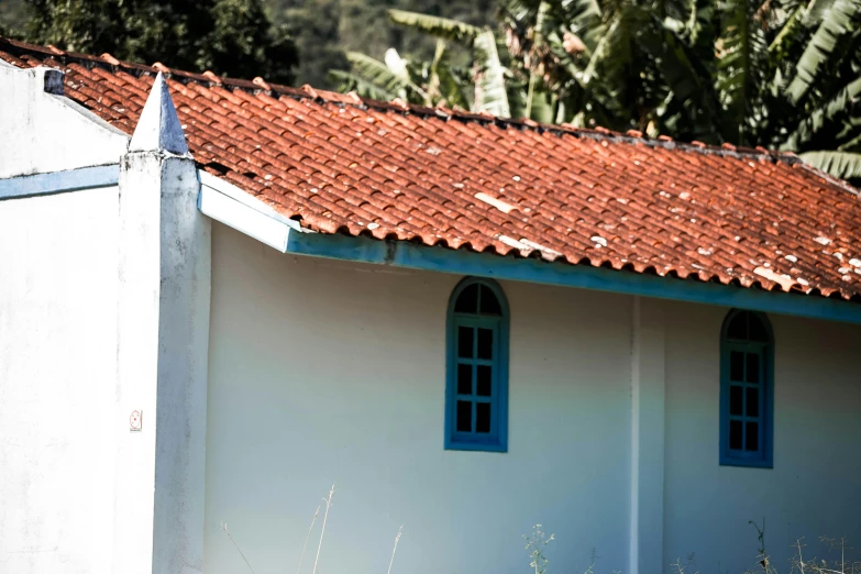 the top half of a building has two windows with red roof tiles