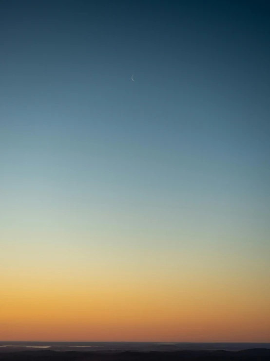 a jet flying in the sky over a mountain